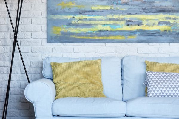 Colorful painting on a white brick wall in cozy living room
